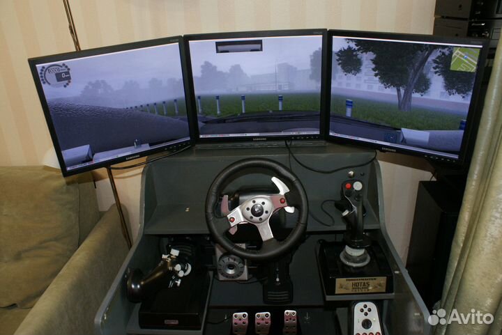 Компьютерный стол с мониторами и джойстиками