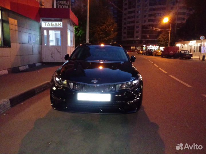 Водитель со своим автомобилем Киа оптима комфорт +