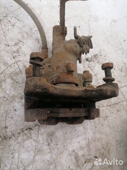 Суппорт тормозной задний левый Nissan Primera P11